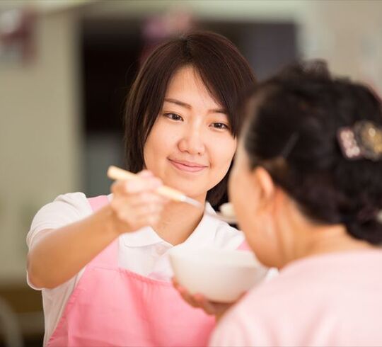 食事の介助をする女性スタッフ